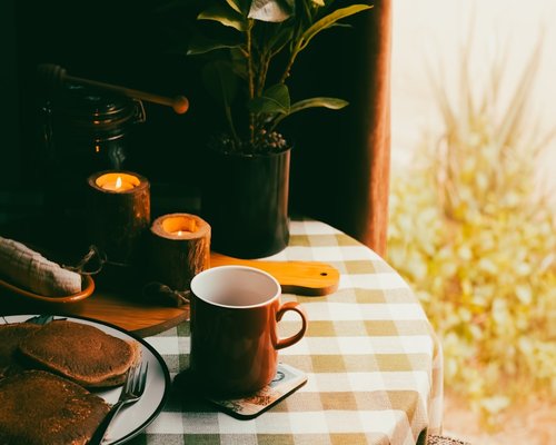 A warm cup of coffee placed on a clean breakfast table with soft lighting